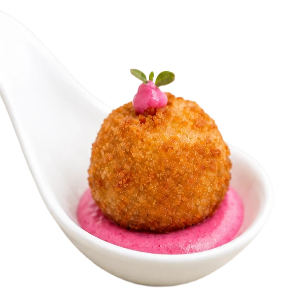 Croquette panée sur crème de betterave, dressée dans une cuillère de porcelaine blanche