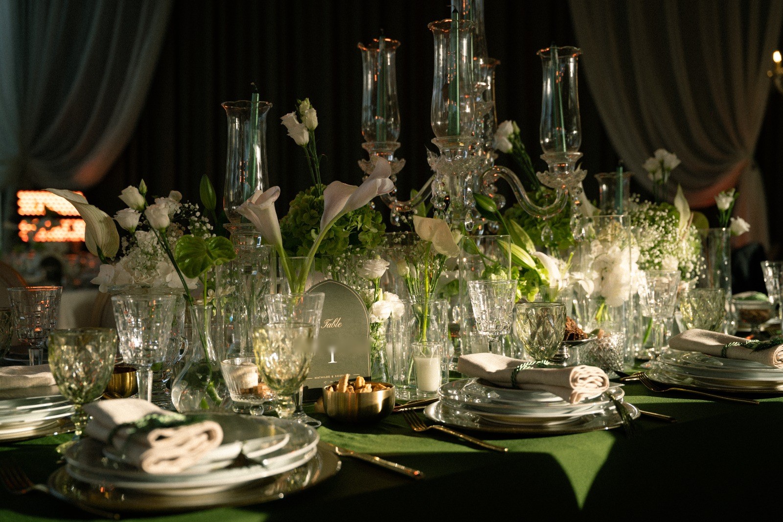 Candélabres de cristal, arums et gypsophile sur une table de velours vert, carton de table